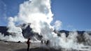People walk among the steam that comes out of a geothermal area.
