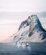 Mountain in Iceland covered with snow and snowmobiling's driving past it 