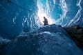A person with a helmet enters an ice cave.