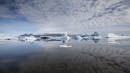 A photo of a glacier lagoon with calm waters creates a reflex.