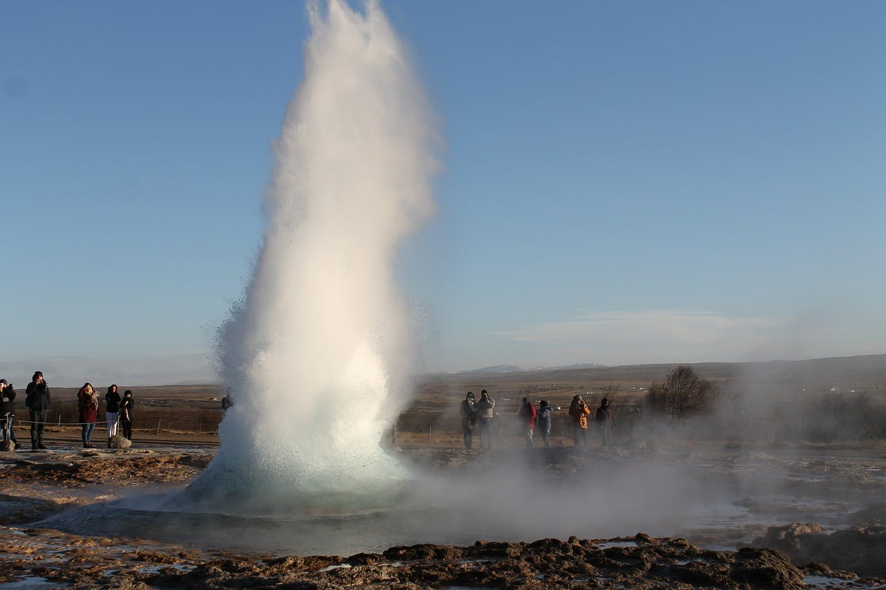 Geysir throws boiling water up in the air.