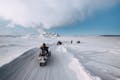 People in Iceland driving snowmobiles on snow
