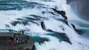 People standing right next to a waterfall.