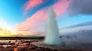 Geysir spew boiling water in the air during a sunset.