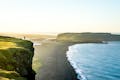 Person standing near a cliff while photographing the landscape during summer time.