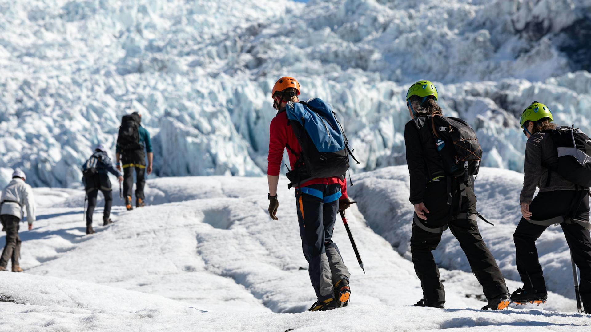 A group of people hiking on a galcier.