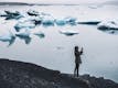 A person taking photos with a mobile of a glacier Lagoon.