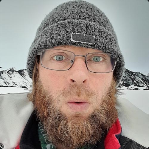 A bearded man looking at the camera.