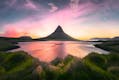 Pyramid shaped mountain on the far side of the lake with sunset colors all around.
